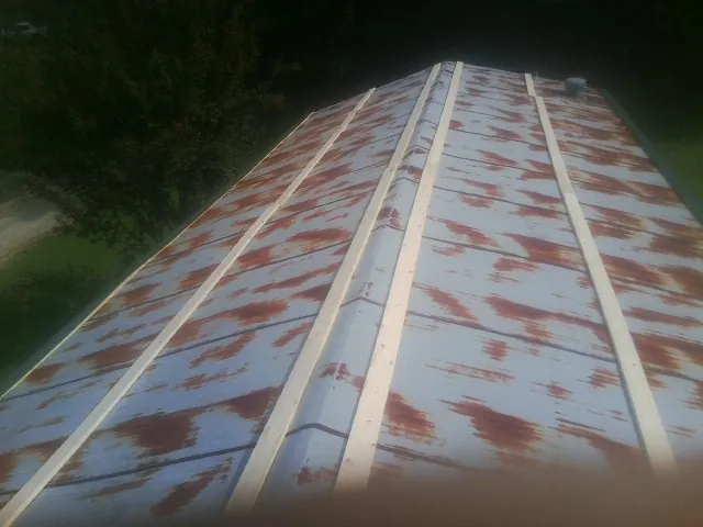 Rusted metal roof panels with new wood purlins before replacement — Storm Damage Roof Repair in Pell City by Roofing Brothers