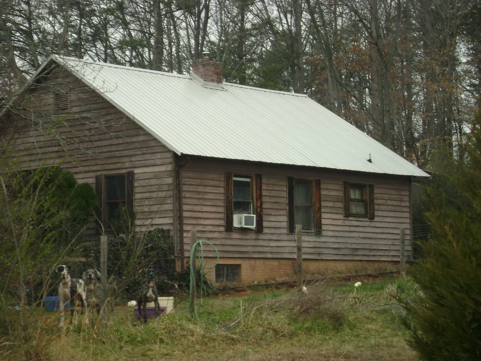 White metal roof on an old wood sided farmhouse, from a Metal Roof Installation job in Pell City